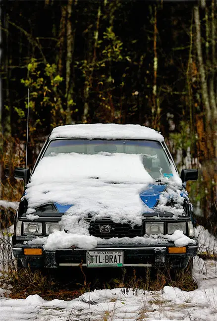 a snow-covered old Subaru