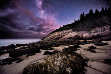 the starry night sky over Sand Beach in Acadia National Park
