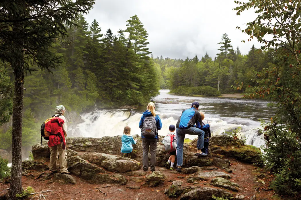The author, Lewis Robinson (in ballcap), and his children, Maisie and Leo (without backpacks), soak up the spectacle of Grand Falls with their hiking companions.