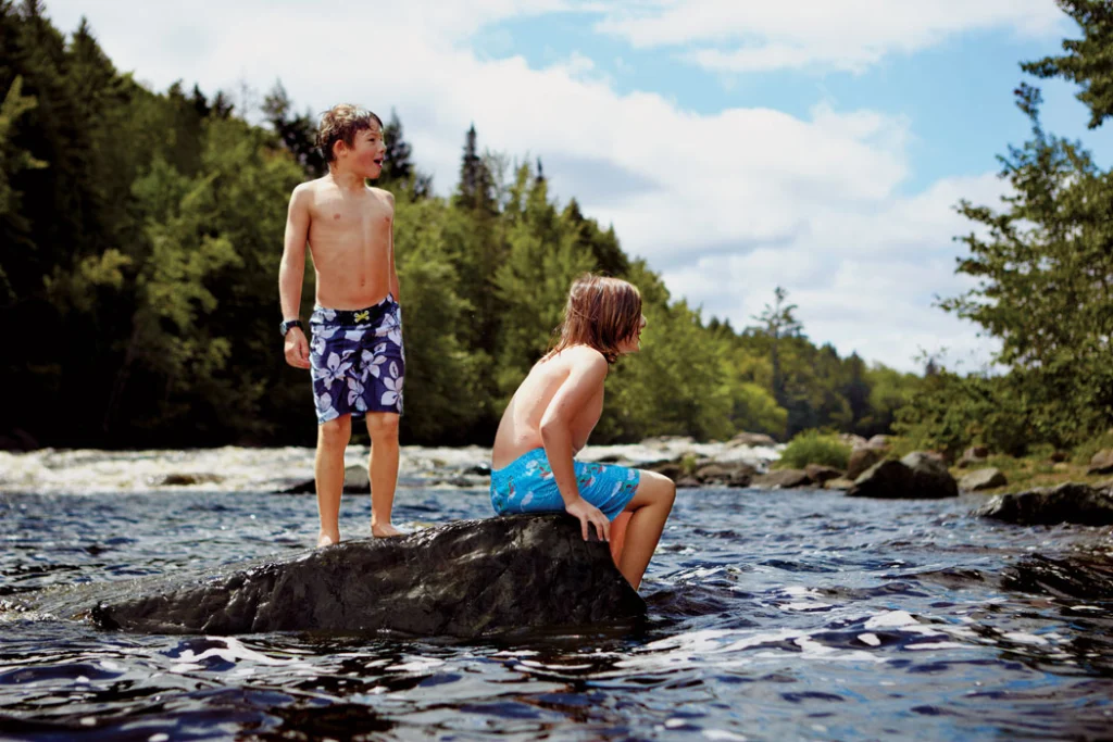 Two boys take a break from swimming in the Dead River near Grand Falls Hut. Located about 34 miles north of Kingfield, Grand Falls is the most secluded of the four backcountry lodges operated by Maine Huts and Trails, and its proximity to the river makes it a favorite of anglers and paddlers.and Trails, and its proximity to the river makes it a favorite of anglers and paddlers.