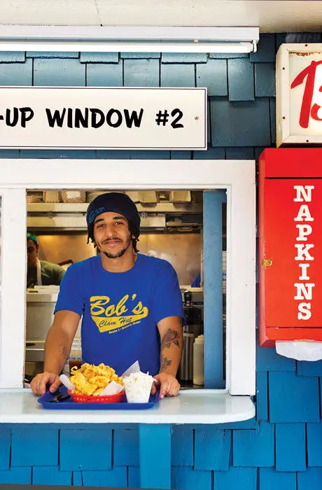 An employee serving fried seafood at Bob’s