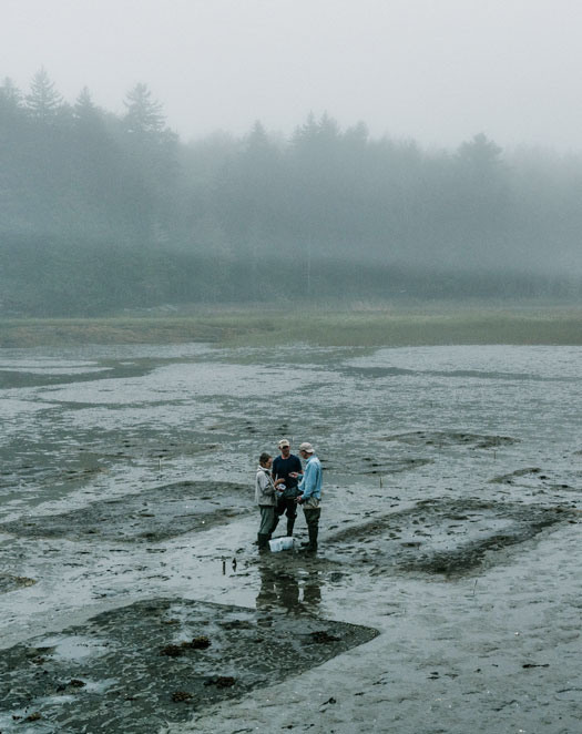 three men in low tide mud