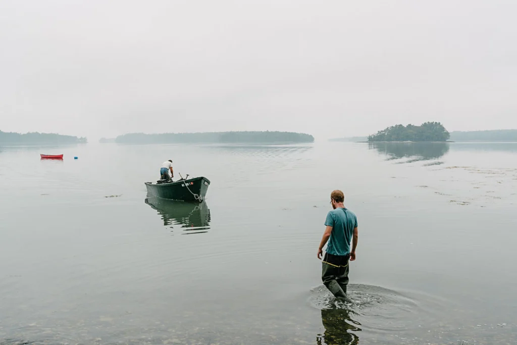 man walking in water to boat
