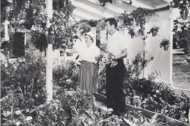 black and white photo of two people standing in a garden room