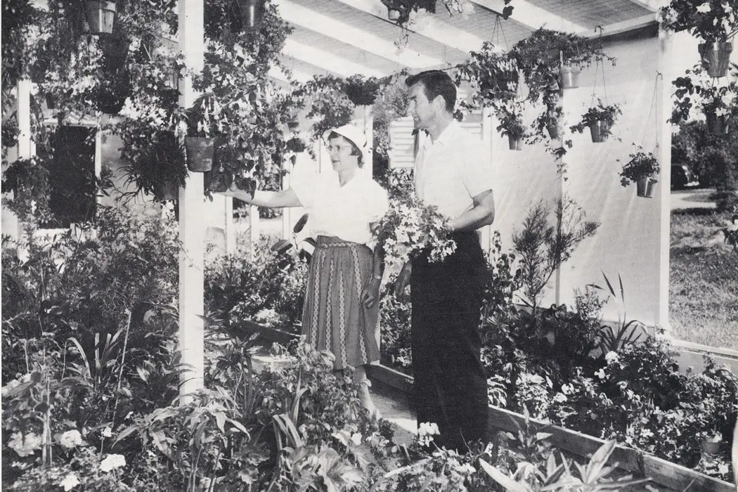 black and white photo of two people standing in a garden room