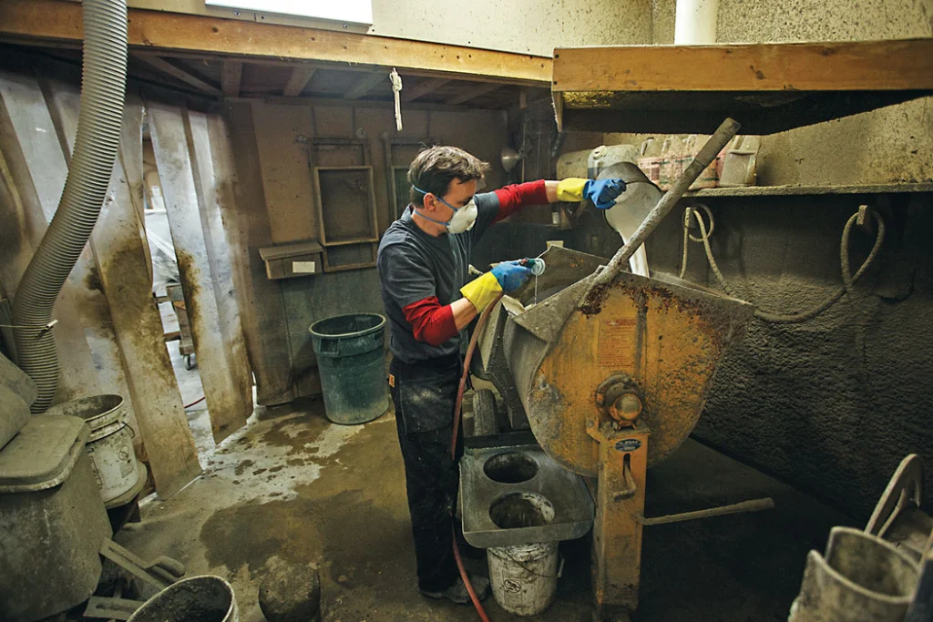 man pouring concrete into mold