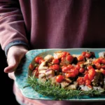 plate of cooked meat and tomatoes with rosemary