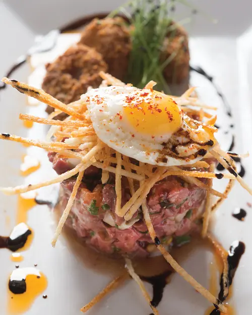 Steak tartare with a quail egg and bone marrow croutons.