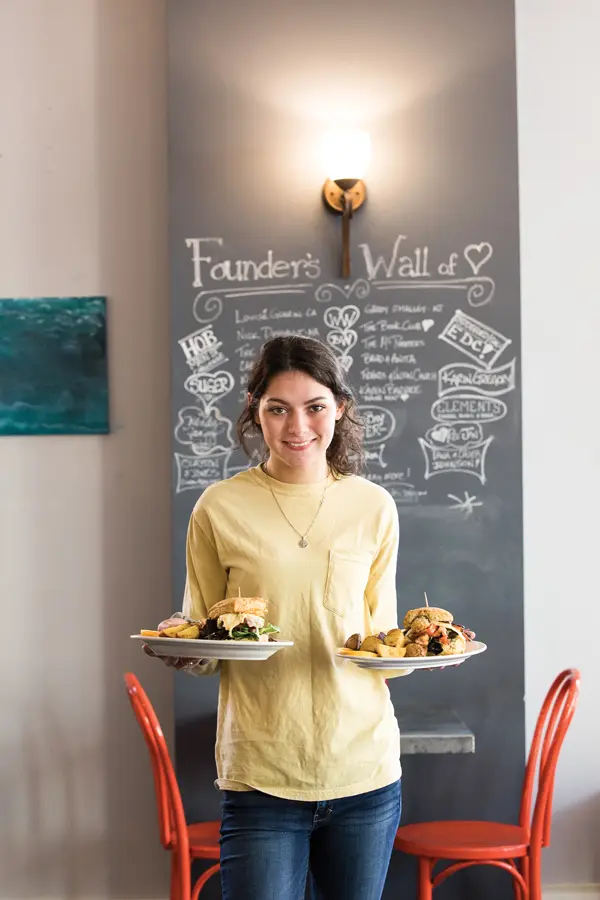 server holding two plates of food