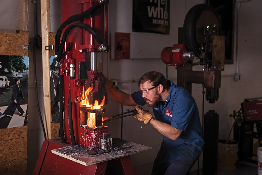 Brant & Cochran metalsmith Gabriel McNeill shapes an ax head for the company’s new line.