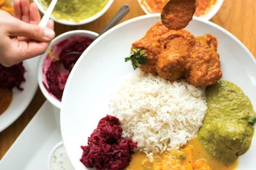 A shareable meal of lamb meatball curry, palak paneer, and butternut-squash and beetroot curries.