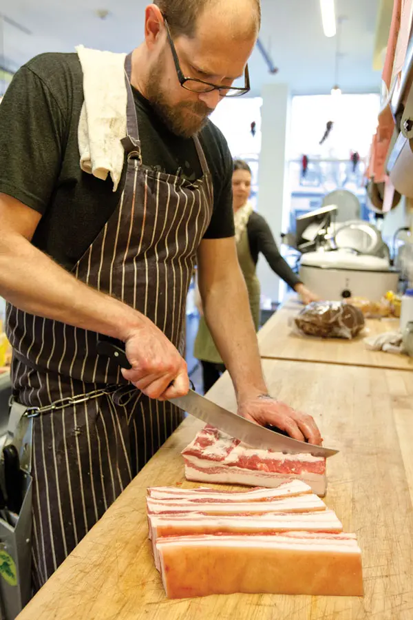 Jarrod Spangler slicing bacon at MEat.