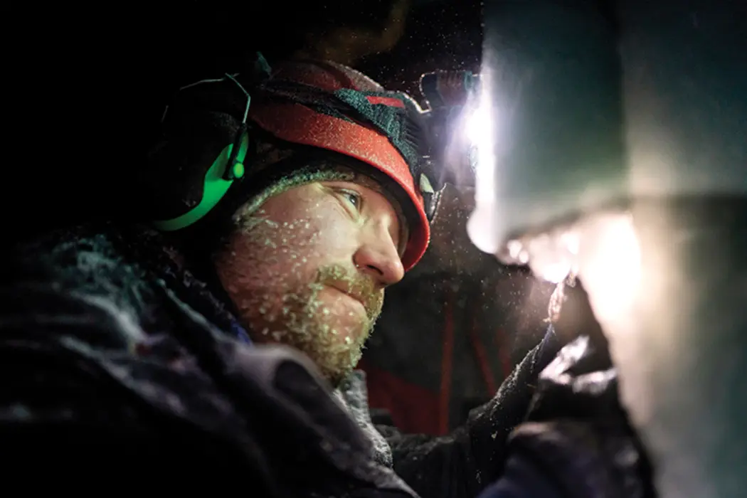 Gerald Baldwin reconnects the power supply for a snow gun after a leak caused ice to build up.