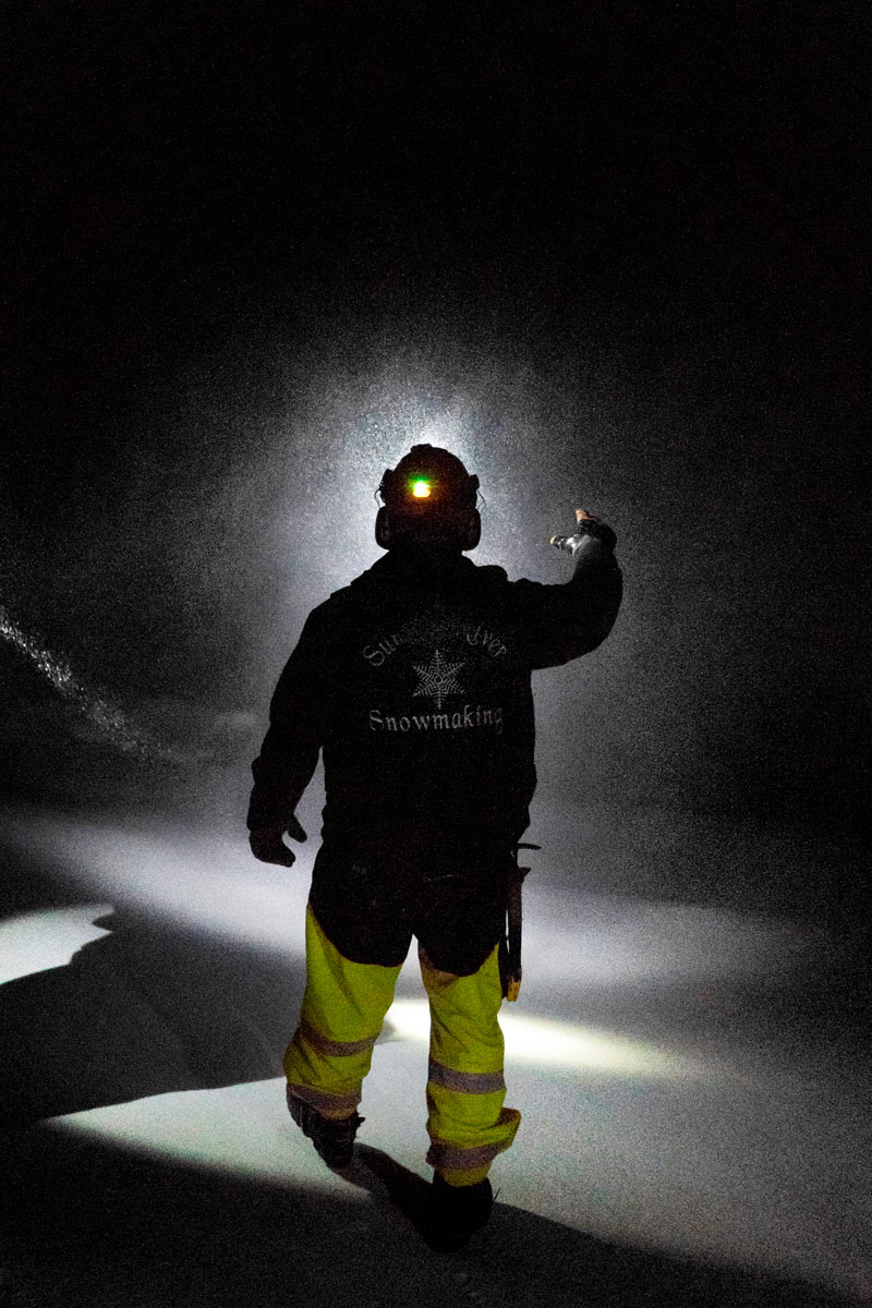 Snowmaker standing in front of a snow gun