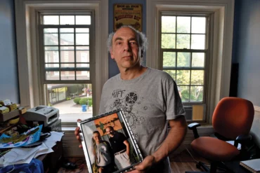 Ken Eisen holds a picture of himself with the late director Jonathan Demme.