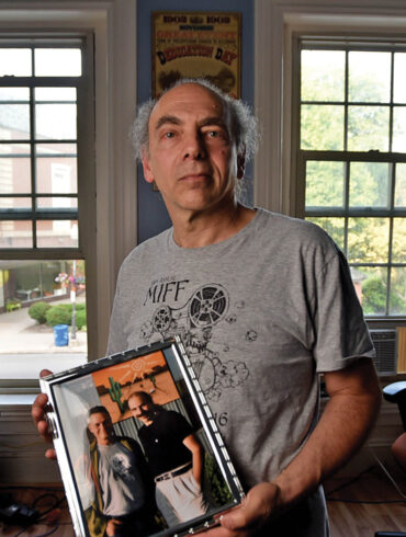 Ken Eisen holds a picture of himself with the late director Jonathan Demme.
