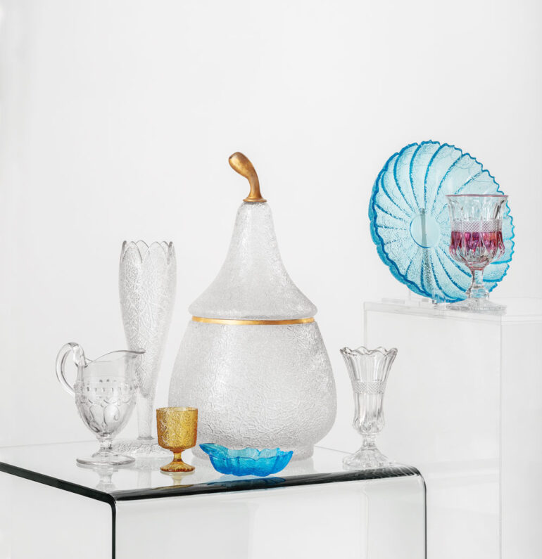 pear punch bowl, tall vase, blue dishes, and gold goblet in Portland Glass Company’s Tree of Life pattern.