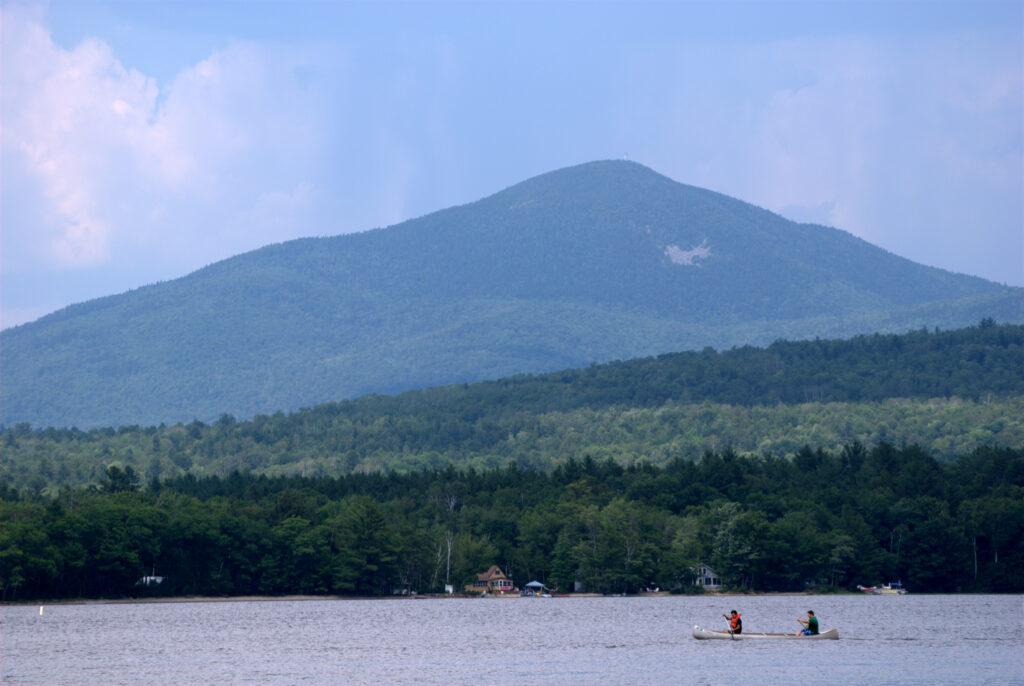 A couple of people in a small boat on Mount Blue State Park lake.