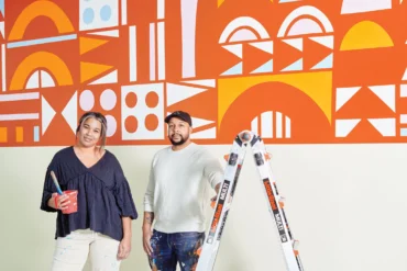 Artists Rachel and Ryan Adams in front of one of their murals at the Children's Museum & Theatre of Maine