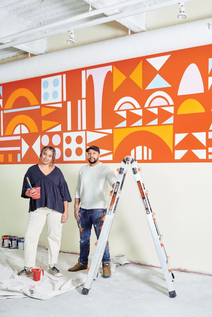 Artists Rachel and Ryan Adams in front of one of their murals at the Children's Museum & Theatre of Maine