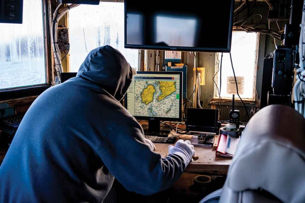 fisherman Randy Cushman looks at charts of the waters around the village of Port Clyde. His family has been fishing in Maine for at least eight generations.