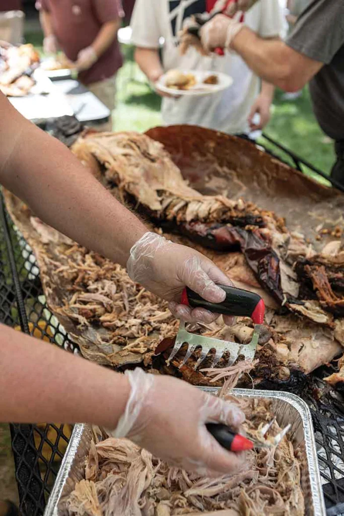 Dana Masters smokes pulled pork for Beast Feast attendees who do not like alligator