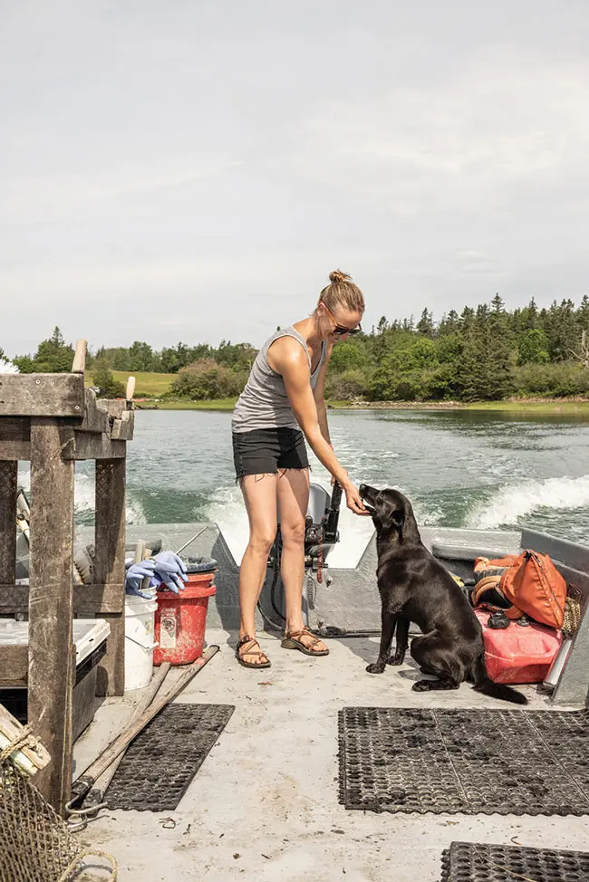 Abby Barrows tending to her oysters with help from dog Fife