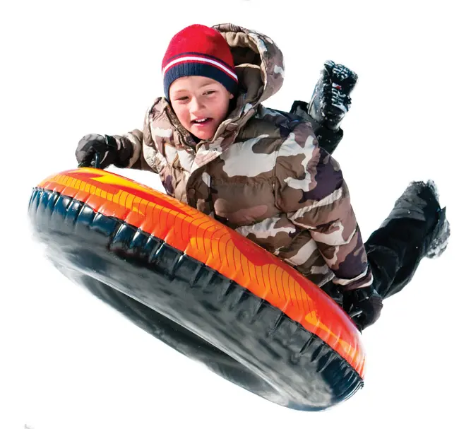 young boy sledding on a tube
