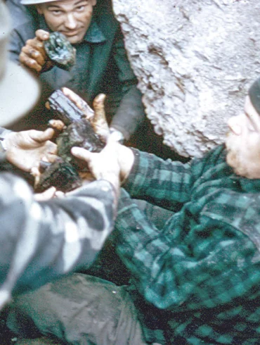 Frank Perham hands muddy crystals up from the floor of a pocket.