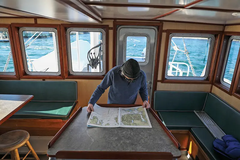 Consulting the map aboard Maine Seacoast Mission’s support vessel, M/V Sunbeam