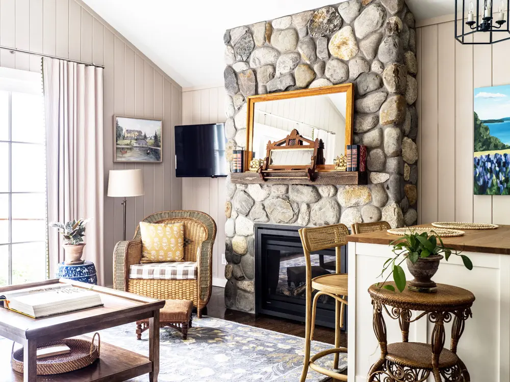 A stone fireplace and wicker furinture in the Morning Glory room at The Claremont.
