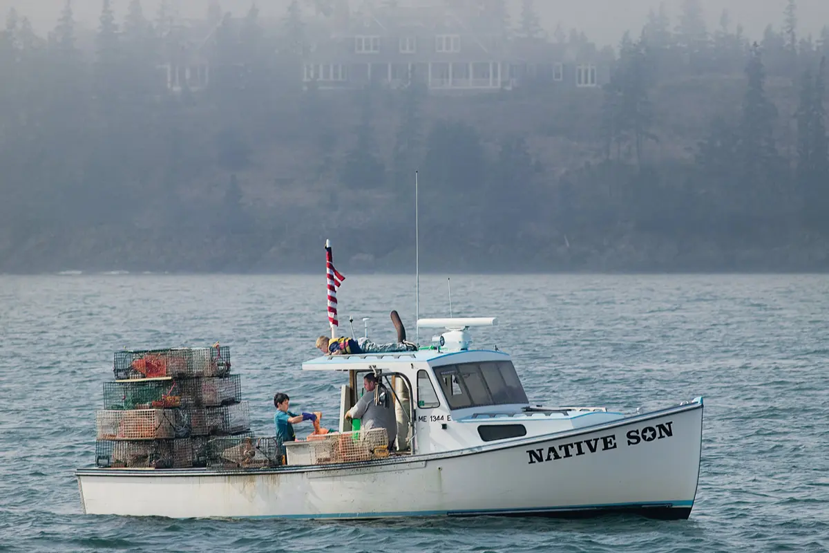 Ralston captured the Native Son hauling traps off North Haven in 2007, a grand summer home looming behind.