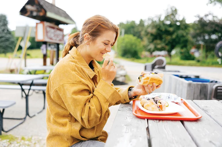 Customer eating a sandwich from the Stow Corner Store