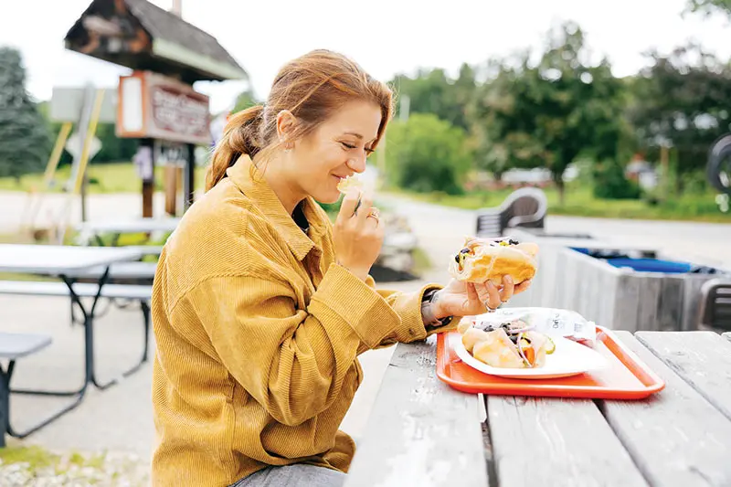 Customer eating a sandwich from the Stow Corner Store