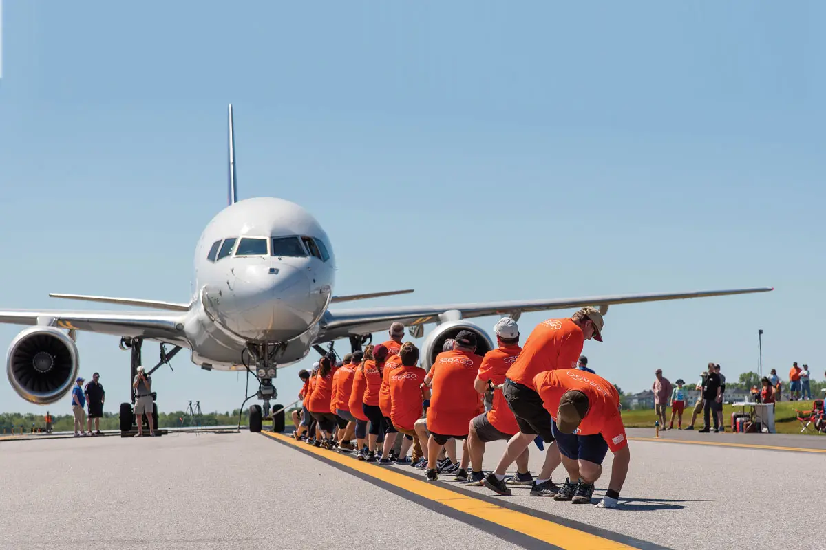 A team of employee-owners from Sebago Technics takes on an 80-ton 747 at the Portland International Jetport, raising funds for the Travis Mills Foundation