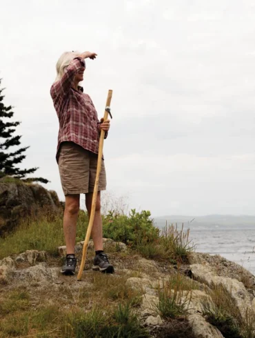 woman hiking with a Greyfeather Woodcraft walking stick