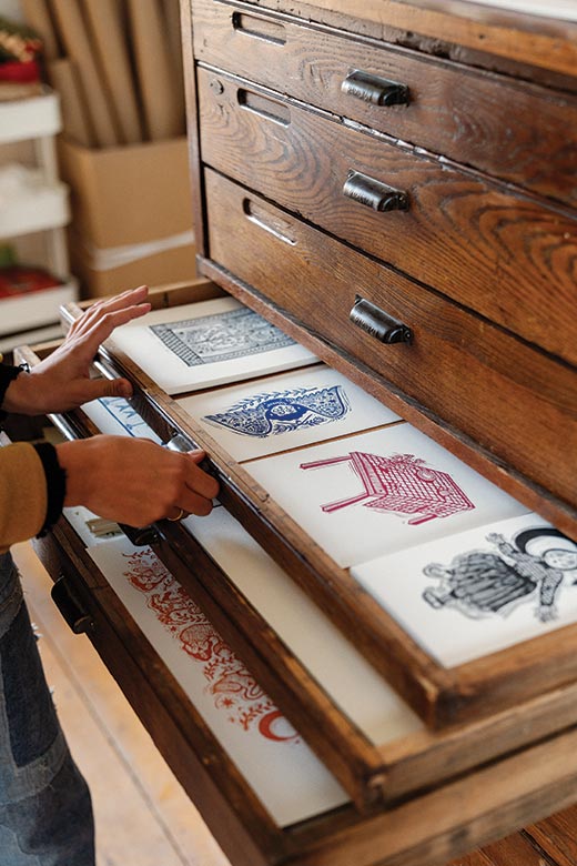 Addie Best opens a drawer of her prints