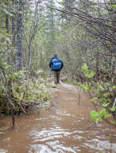 man walking through Mud Pond Carry