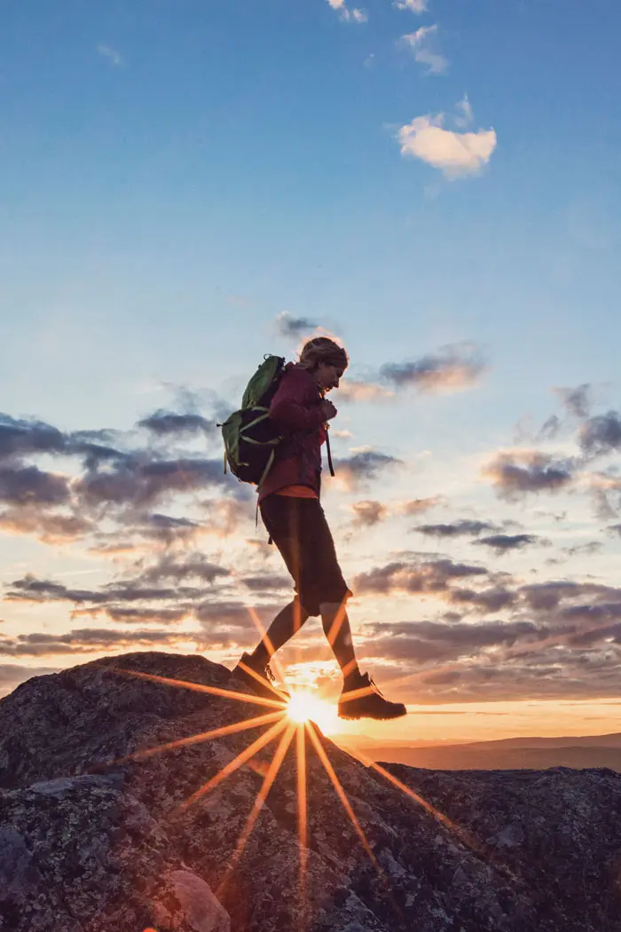 hiker at the summit of a mountain in the Maine’s 100 Mile Wilderness at sunrise