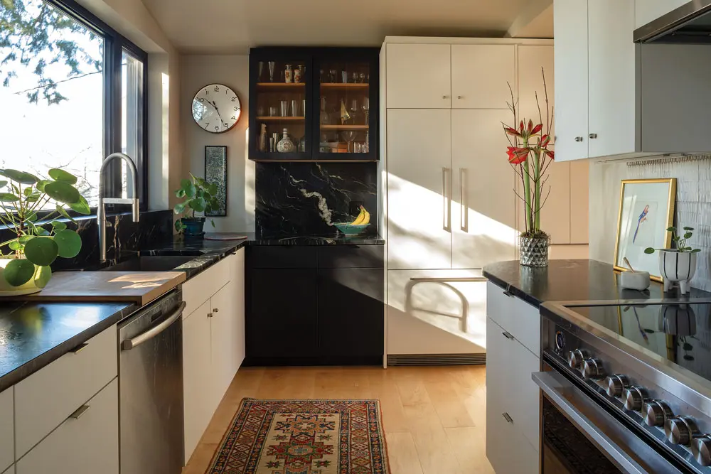 A leathered- granite backsplash and countertops from Stone Surface and an artful relief-tile backsplash from Portland’s Distinctive Tile & Design play up the black-and-white palette 