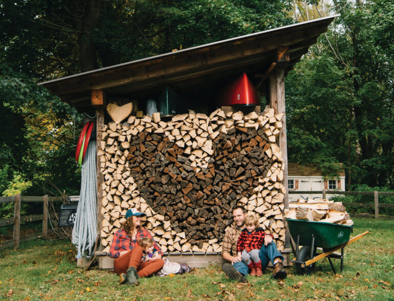 South Berwick’s Emily McLaughlin, Tom Beattie, and their 4-year-old twins, Willa and Gus, hang out by the heart they created with ash and walnut firewood.