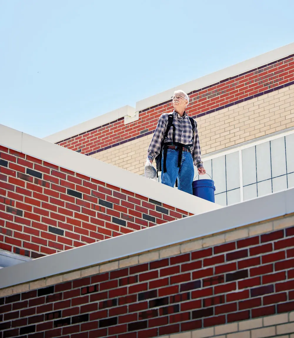 Jon Wallace on a roof searching for micrometeorites