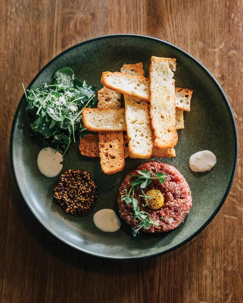 A pepper-flecked egg yolk beefs up steak tartare at a Bethel après-ski spot