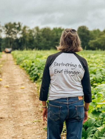 Good Shepherd Food Bank volunteer walking through a farm field
