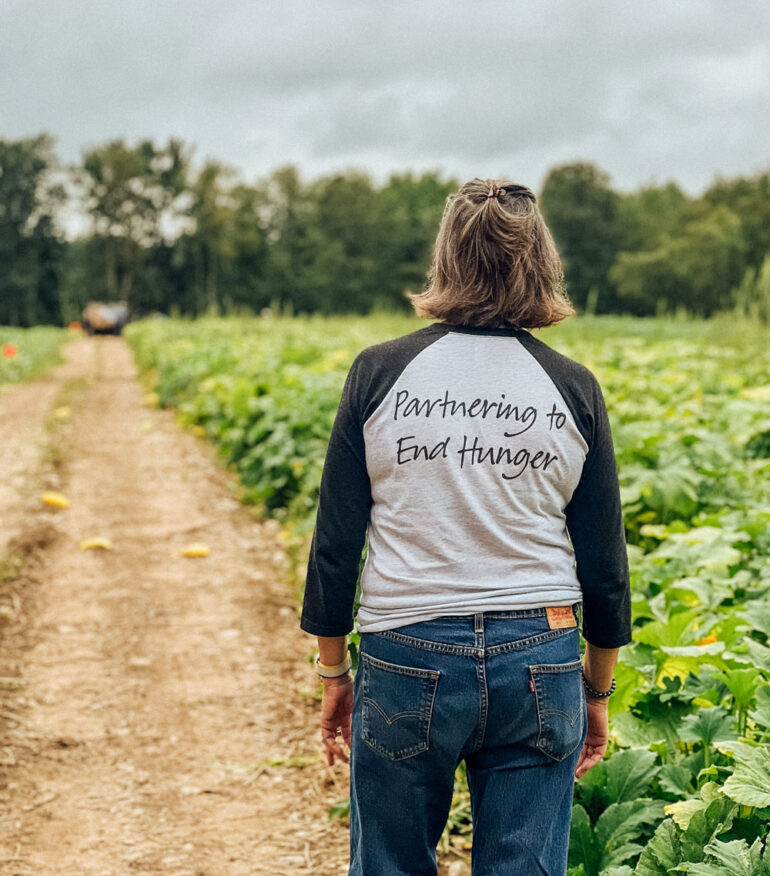 Good Shepherd Food Bank volunteer walking through a farm field