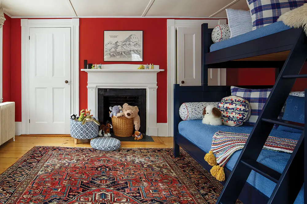 Crisp white woodwork sets off walls in Benjamin Moore’s Cochineal Red in boys' room