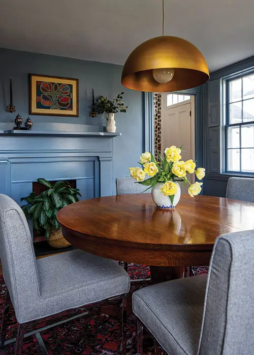 Benjamin Moore’s Chiswell Blue — a historic shade inspired by homes and artifacts found in Colonial Williamsburg — on the walls and woodwork adds drama to the small dining space