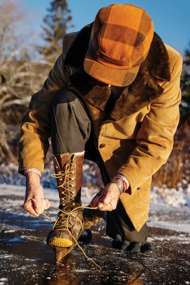 Harold Crosby lacing up his homemade blades onto old hunting boots