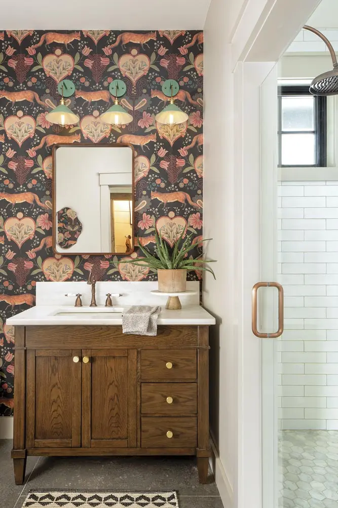 a powder room furnished with Mind The Gap wallpaper, iYoee sconces, and a Signature Hardware vanity