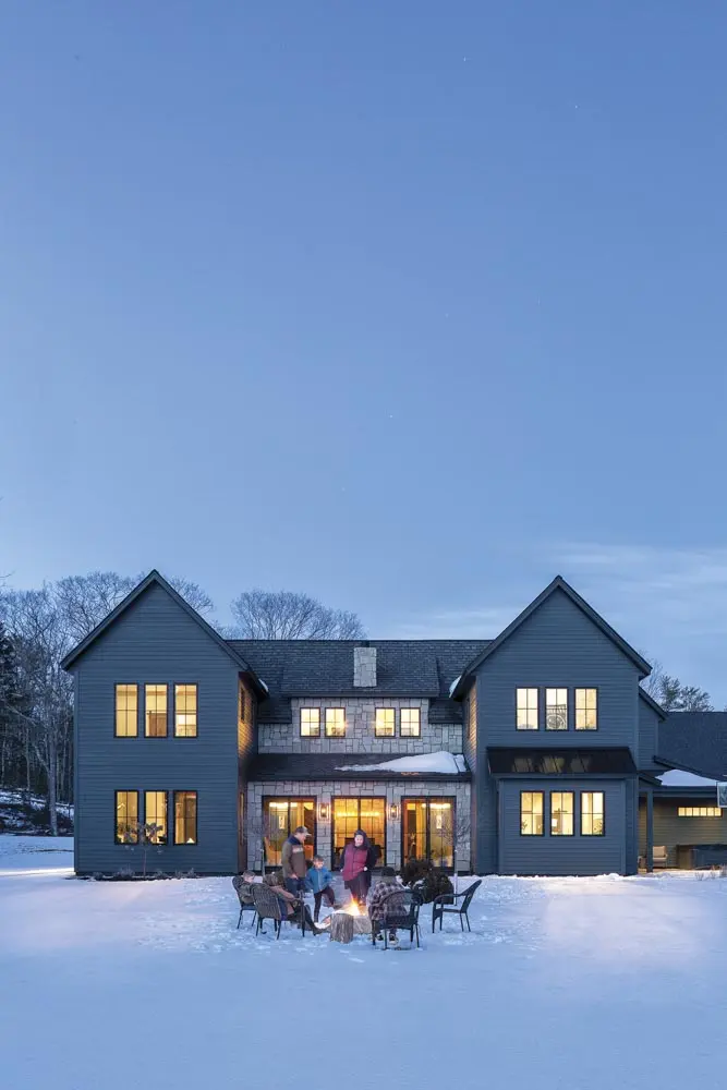 a home with a limestone exterior, copper gutters, and a faux-slate roof